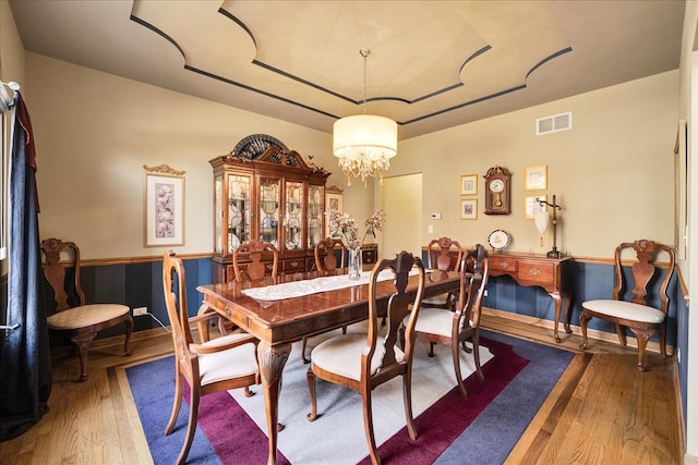 dining space featuring hardwood / wood-style floors and an inviting chandelier