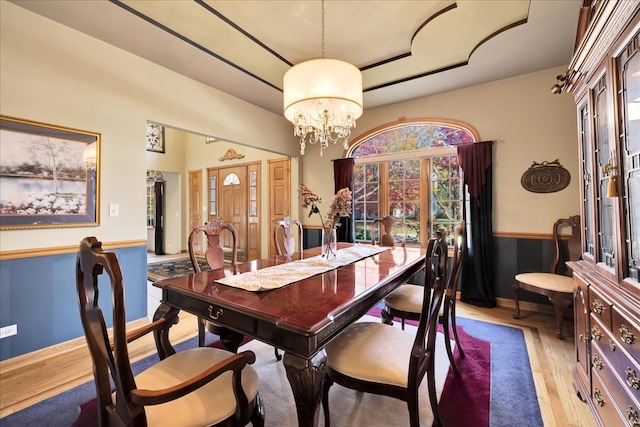 dining space with light hardwood / wood-style floors, a notable chandelier, and a wealth of natural light