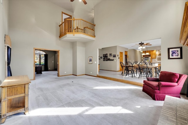 carpeted living room featuring a high ceiling and ceiling fan