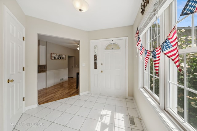 foyer featuring light tile patterned flooring and a wealth of natural light