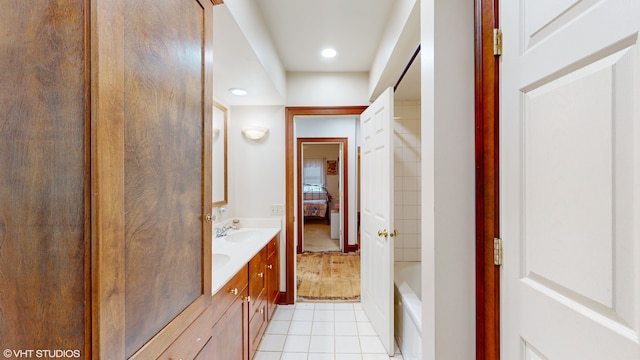 bathroom featuring vanity, a tub to relax in, and tile patterned floors