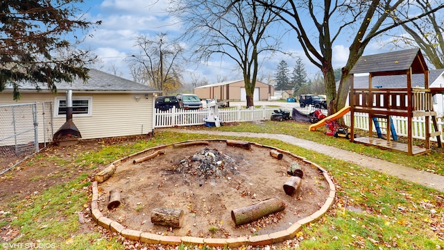 view of yard with a playground and a fire pit