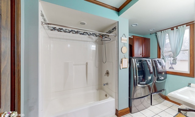 bathroom with shower / tub combination, tile patterned flooring, washer and dryer, and sink