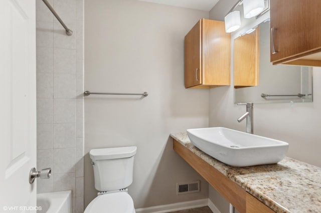 full bathroom featuring sink, tiled shower / bath combo, and toilet