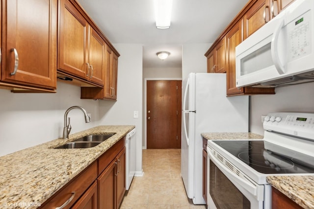 kitchen featuring sink, white appliances, light stone countertops, and light tile patterned flooring