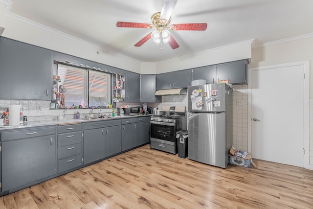 kitchen with gray cabinetry, tasteful backsplash, appliances with stainless steel finishes, sink, and light hardwood / wood-style floors