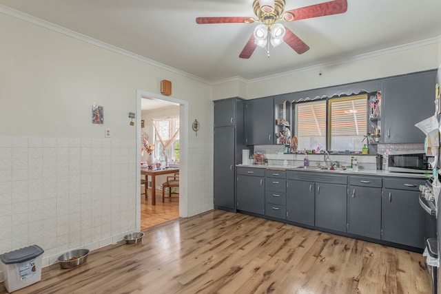 kitchen featuring gray cabinets, tile walls, ornamental molding, light hardwood / wood-style floors, and sink