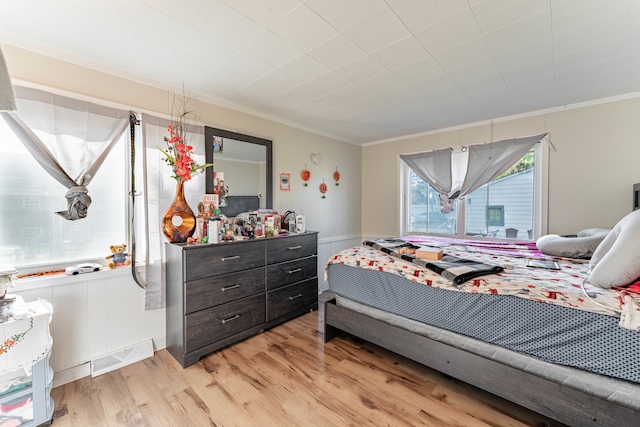 bedroom with crown molding and light wood-type flooring