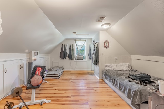 bedroom featuring lofted ceiling, cooling unit, and light wood-type flooring