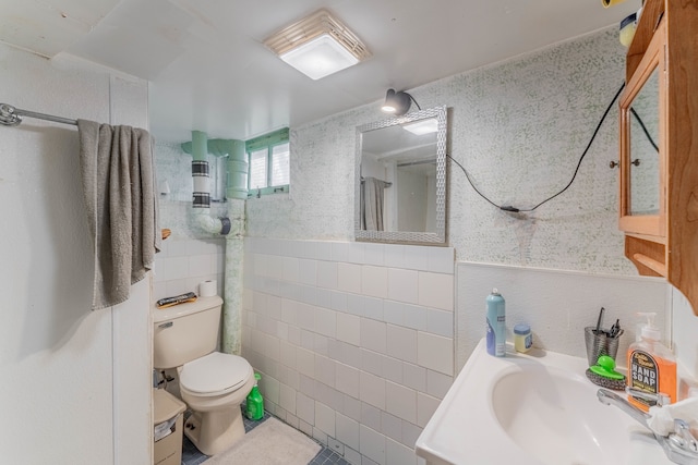 bathroom with toilet, vanity, tile walls, and tile patterned flooring