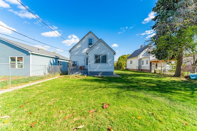 rear view of house featuring a lawn