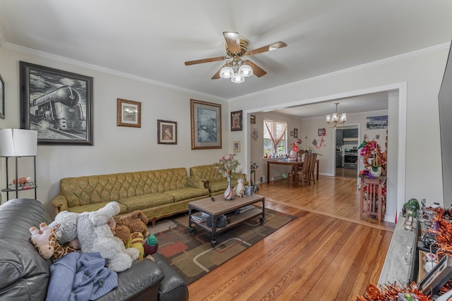 living room with crown molding, hardwood / wood-style flooring, and ceiling fan with notable chandelier