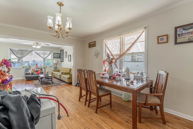 dining area featuring crown molding, ceiling fan with notable chandelier, and light wood-type flooring