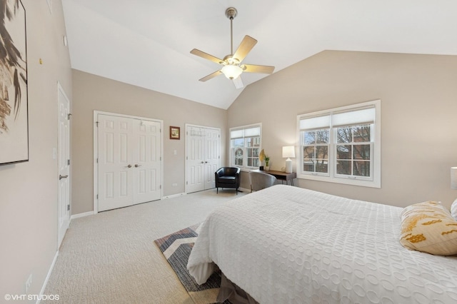 bedroom featuring ceiling fan, multiple closets, high vaulted ceiling, and light colored carpet