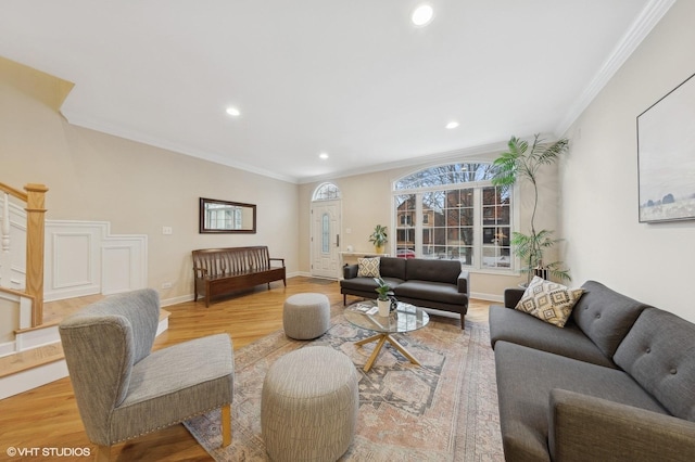 living room with ornamental molding and light hardwood / wood-style flooring