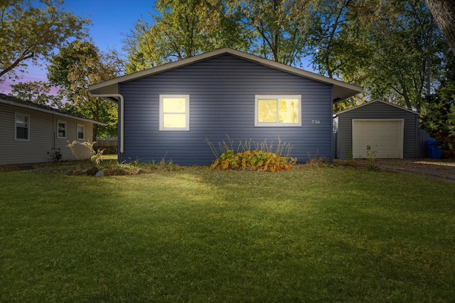 view of front of house with a yard, a garage, and an outbuilding