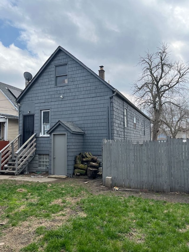 rear view of property featuring a yard