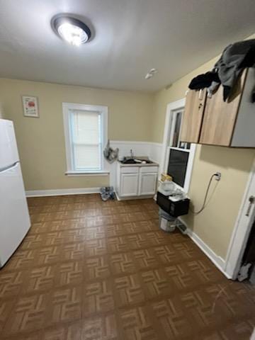 laundry room with cabinets and dark parquet flooring