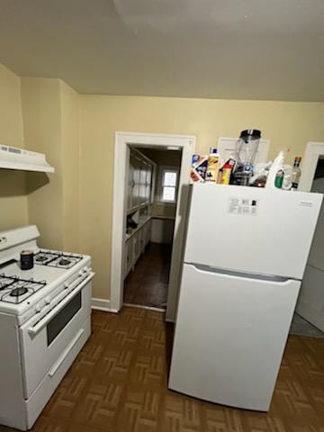 kitchen featuring dark parquet flooring, range hood, and white appliances