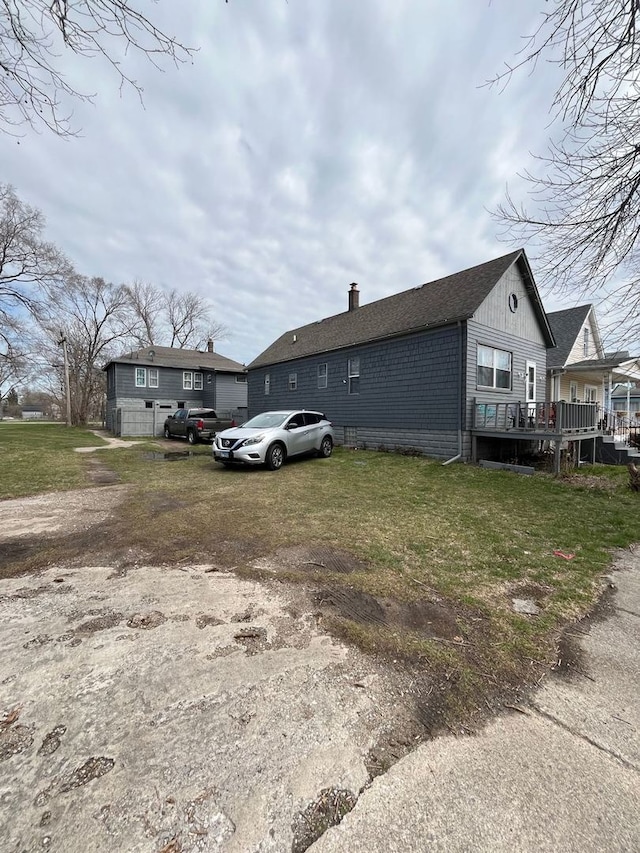 view of side of home featuring a wooden deck and a lawn