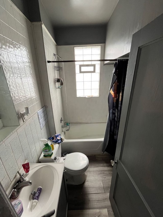 full bathroom with toilet, shower / bath combo with shower curtain, tile walls, vanity, and hardwood / wood-style flooring