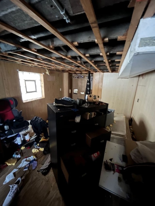 basement featuring wooden walls