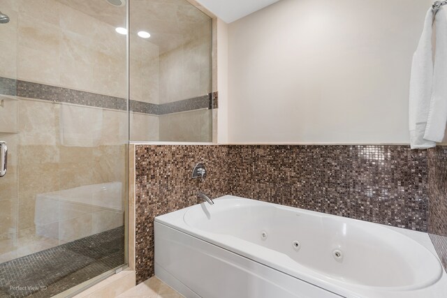 bathroom featuring independent shower and bath and tile walls