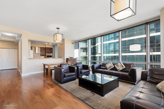 living room featuring light wood-type flooring and floor to ceiling windows