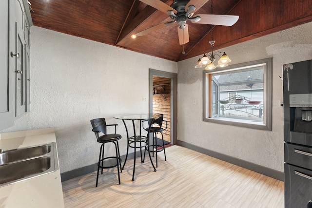 dining room with wooden ceiling, ceiling fan with notable chandelier, and vaulted ceiling