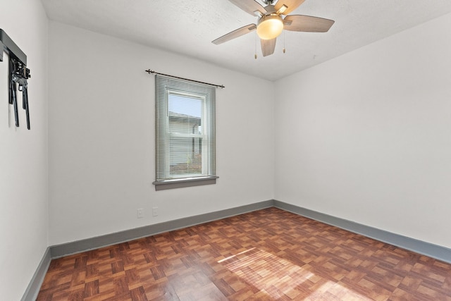 unfurnished room featuring dark parquet flooring, a textured ceiling, and ceiling fan