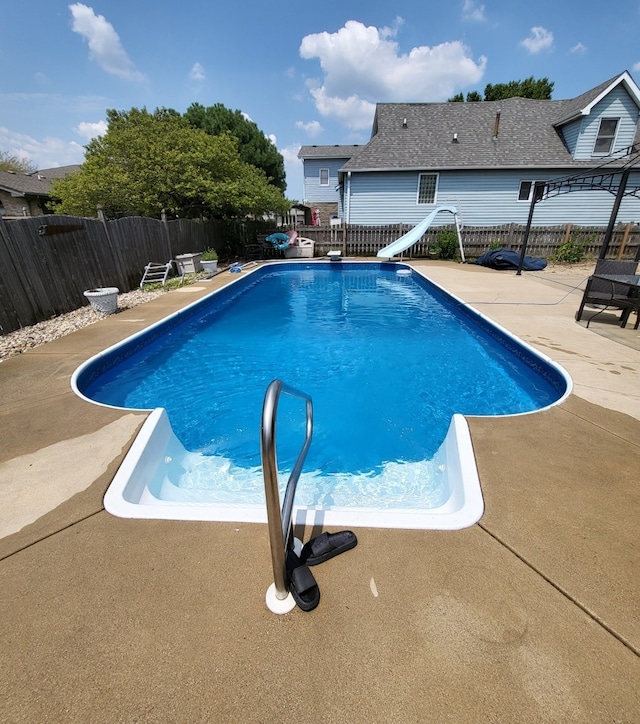 view of pool with a water slide and a patio area