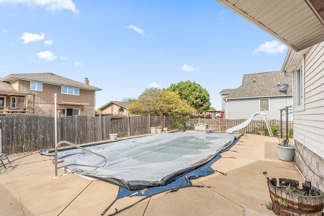 view of swimming pool with a patio area and a water slide