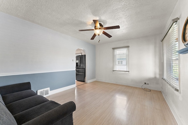 sitting room featuring light hardwood / wood-style flooring, a textured ceiling, and ceiling fan