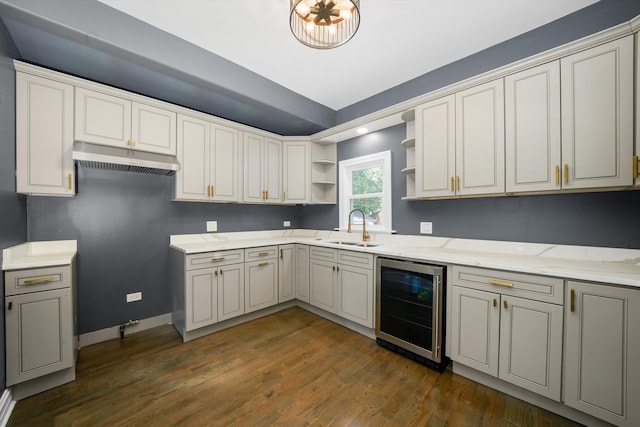 kitchen with beverage cooler, sink, white cabinets, dark wood-type flooring, and light stone counters