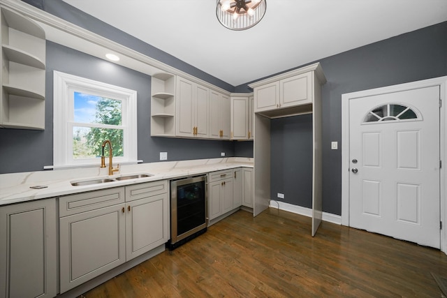 kitchen with wine cooler, sink, light stone countertops, and dark hardwood / wood-style flooring