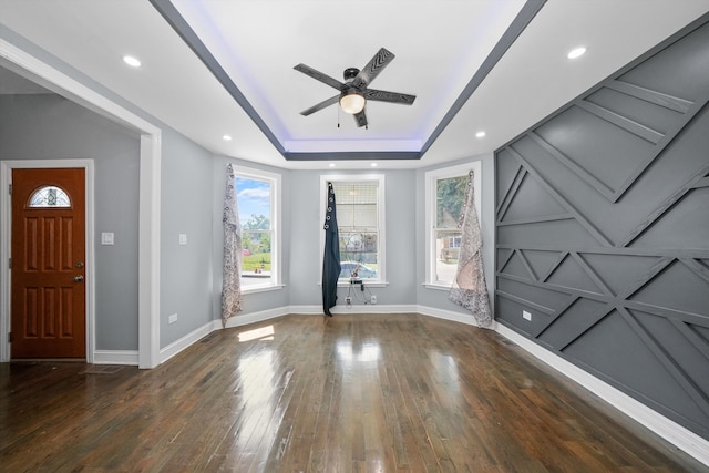 foyer featuring ceiling fan, a raised ceiling, and dark hardwood / wood-style floors