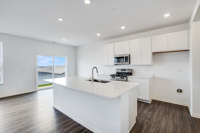 kitchen with recessed lighting, appliances with stainless steel finishes, dark wood-type flooring, white cabinets, and a sink