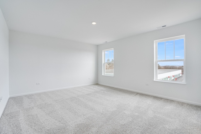 carpeted empty room featuring recessed lighting, visible vents, and baseboards