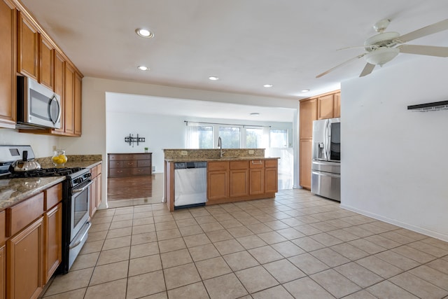 kitchen with ceiling fan, stainless steel appliances, light stone countertops, and light tile patterned flooring