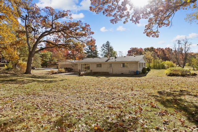 rear view of house featuring a patio area and a lawn