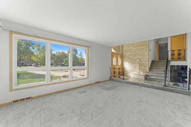 unfurnished living room with carpet floors and a fireplace