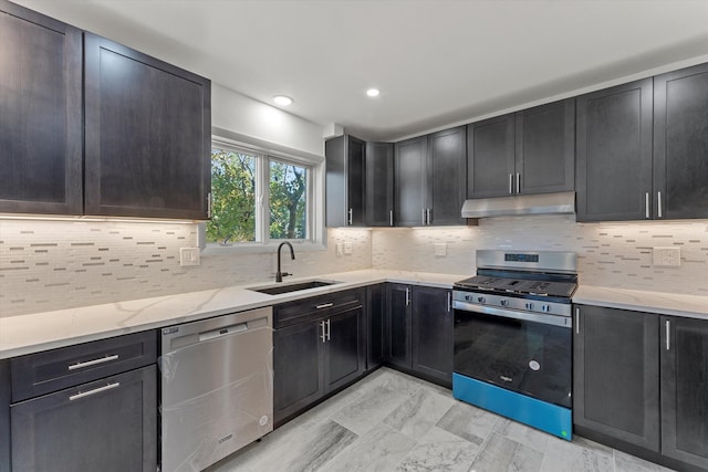 kitchen with backsplash, stainless steel appliances, light stone countertops, and sink