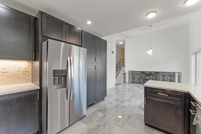 kitchen featuring stainless steel fridge, hanging light fixtures, and backsplash