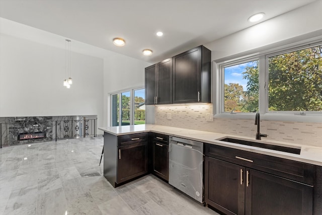 kitchen with sink, dishwasher, decorative light fixtures, and plenty of natural light