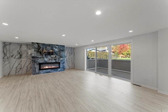 unfurnished living room with light hardwood / wood-style flooring and a large fireplace