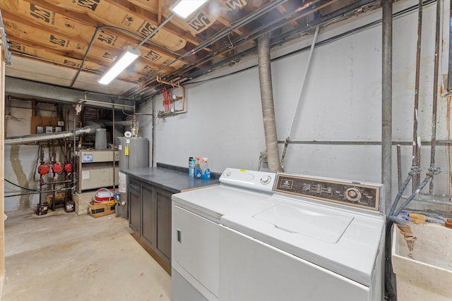 laundry room with water heater and washer and dryer