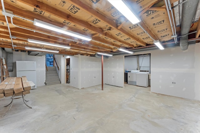 basement with independent washer and dryer and white fridge