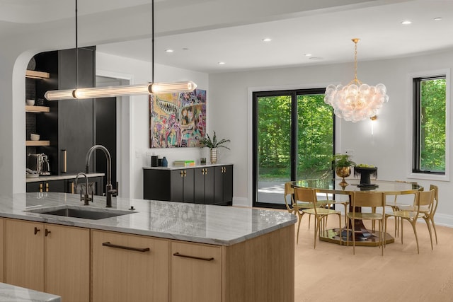 kitchen featuring light stone counters, sink, plenty of natural light, and light brown cabinets