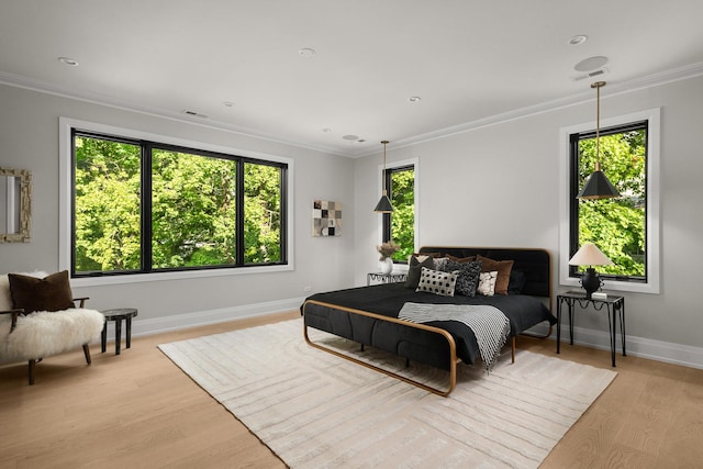 bedroom with light hardwood / wood-style floors and ornamental molding