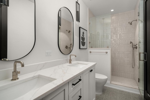 bathroom with tile patterned floors, toilet, vanity, and tiled shower